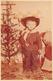 Chłopczyk w kowbojskim stroju przy choince