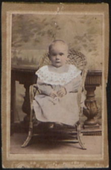 Dziecko w wiklinowym foteliku [fotografia]