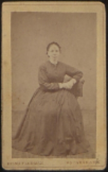 Kobieta siedząca na krześle [fotografia]